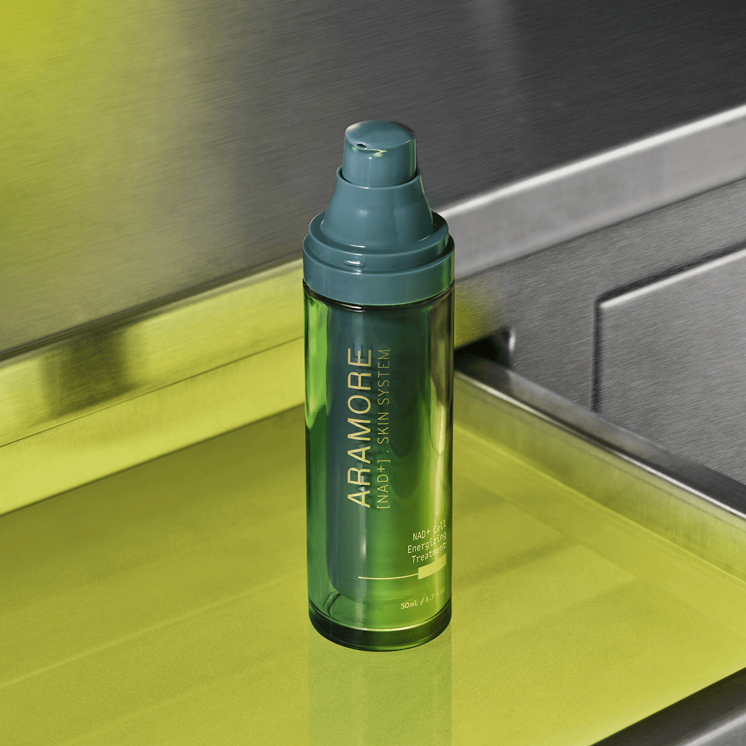 Green Aramore NAD+ Cell Energizing Treatment bottle with a pump dispenser on a metallic surface