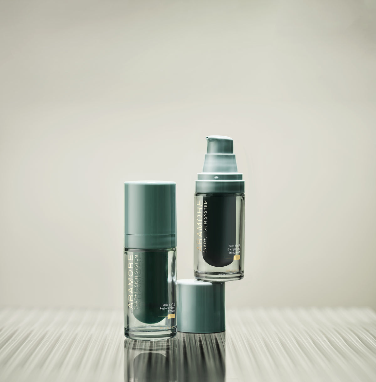 15ml Aramore NAD+ Cell Energizing Treatment bottle and 15ml Aramore NAD+ Cell Restoration Cream bottle on a white background