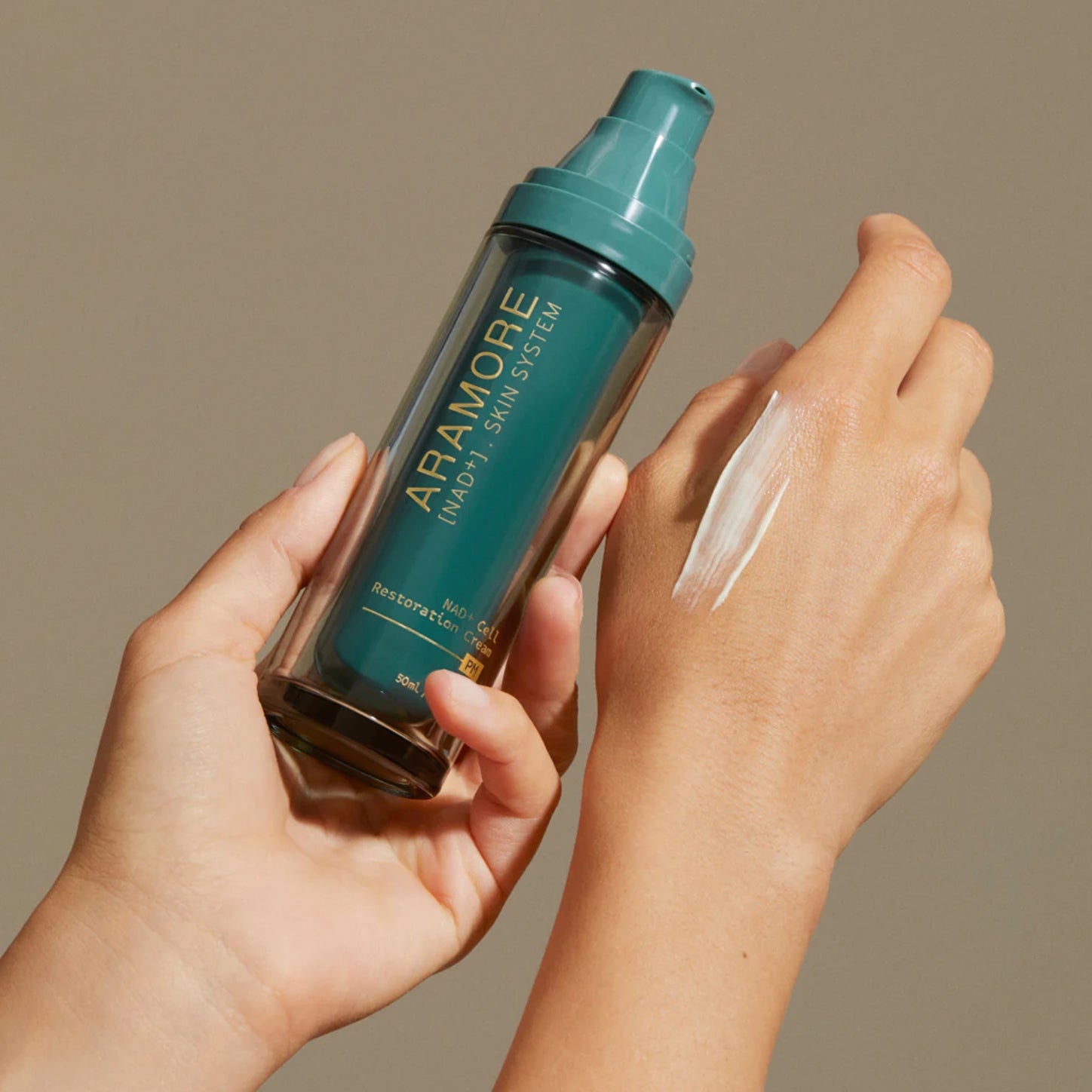 A person applying Aramore skin cream on their hand.
