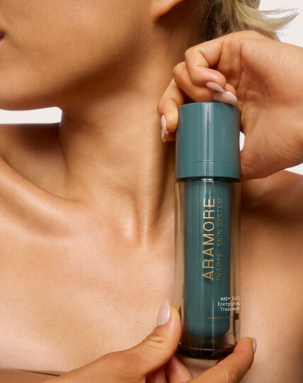 Woman holding the Aramore NAD+ Skin System bottle